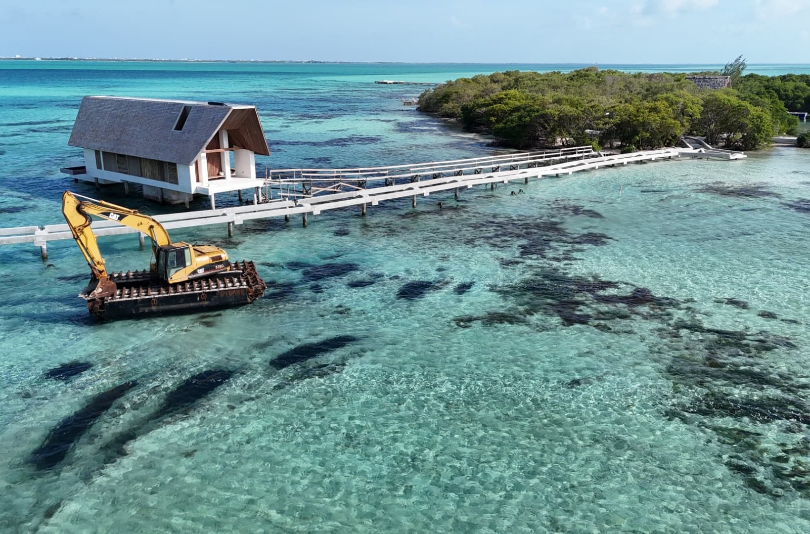Aerial view of the Six Senses Belize island and overwater structures in clear turquoise water